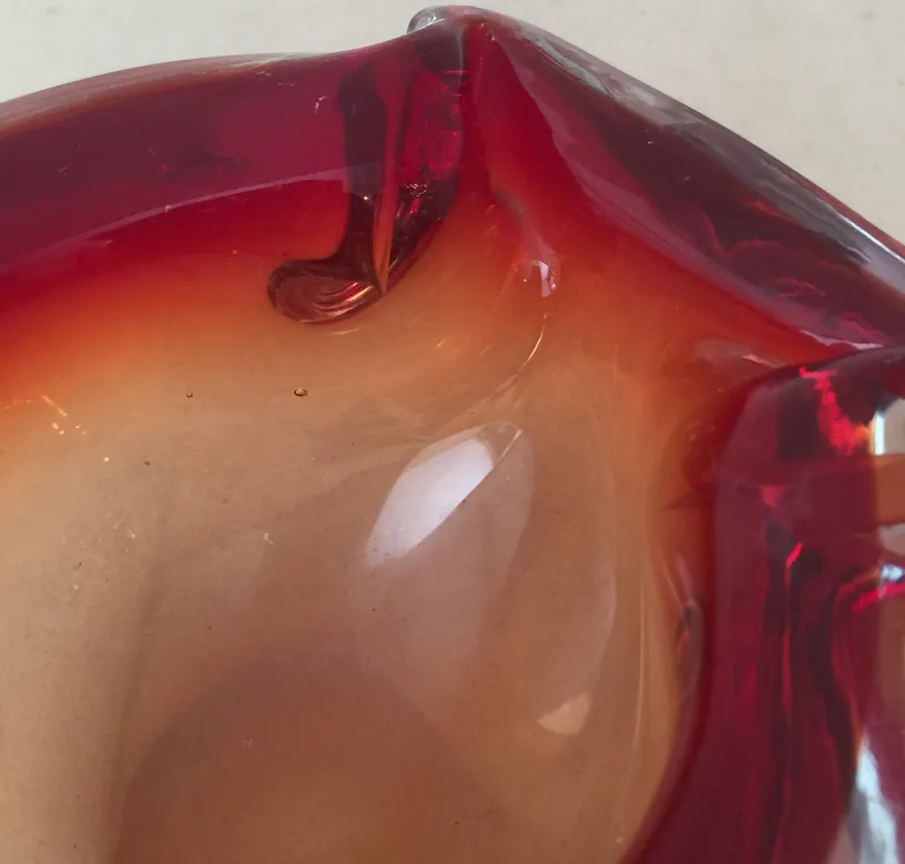 Escultura antiga de cristal de Murano em tons de vermelho e laranja.