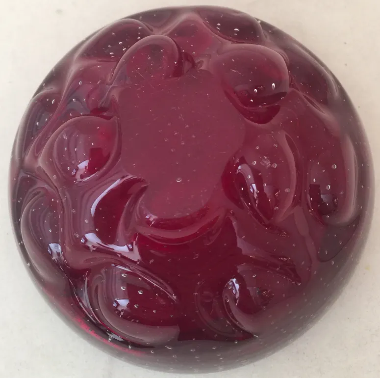 Antique Murano glass decorative piece in red with a flowing design and bubbles.