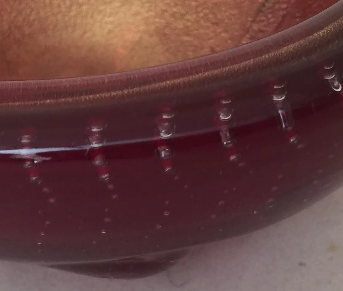 detail eines antiken murano-glas mit roten akzenten und luftblasen