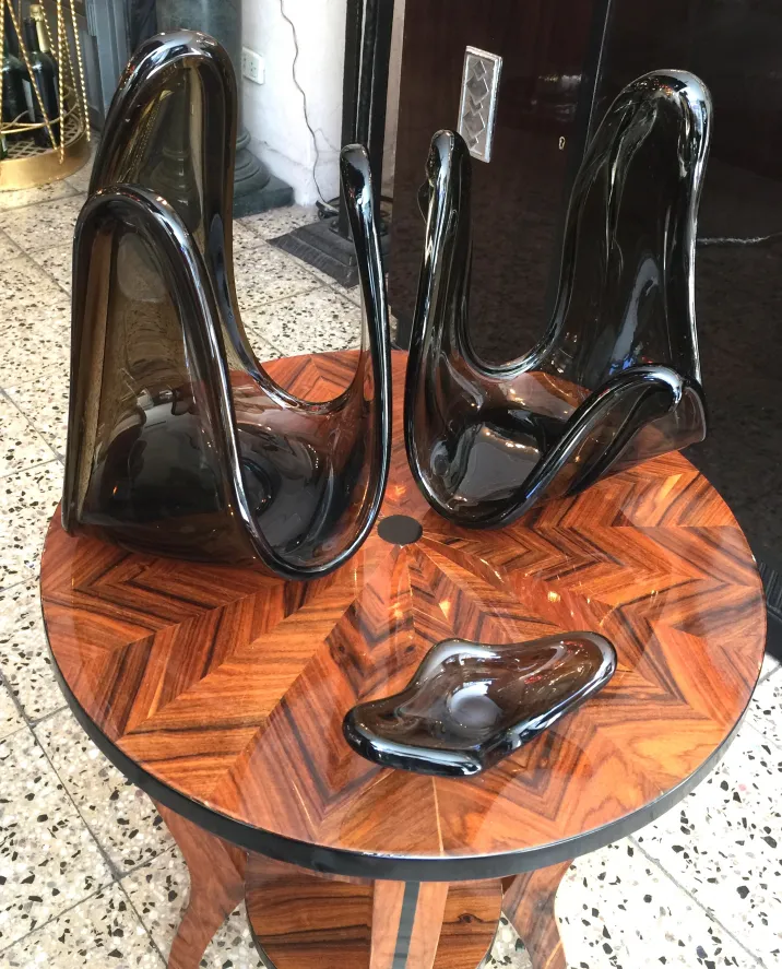 Tre sculture antiche in vetro di murano su un tavolo di legno