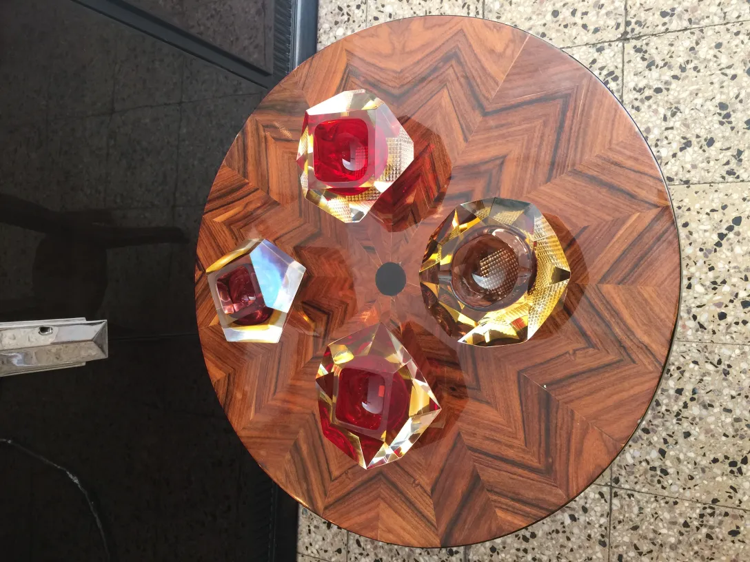 quatro peças de cristal de murano sobre uma mesa de madeira