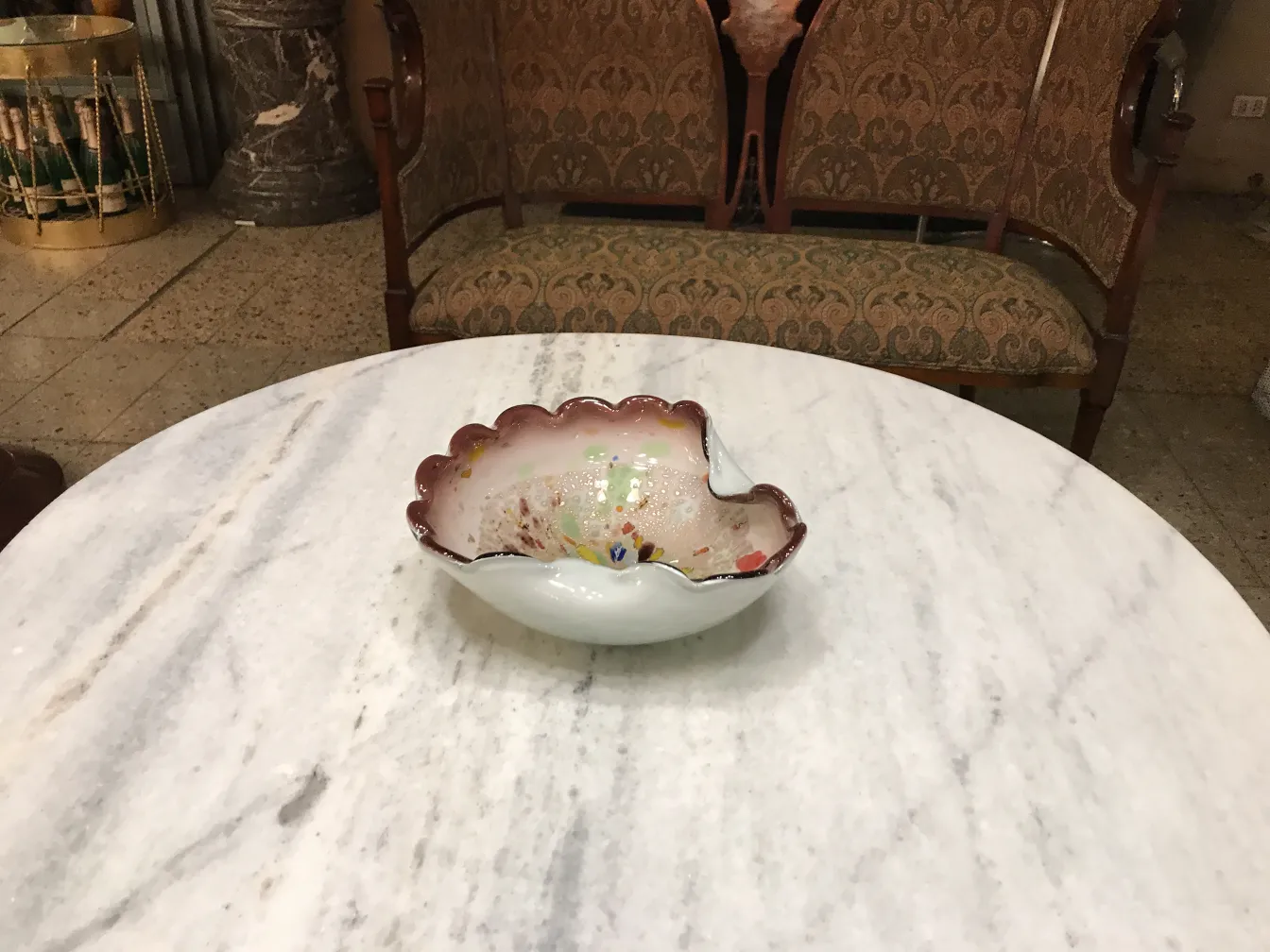 고대 장식용 무라노 유리 조개 모양 작품, 생생한 색상으로 대리석 테이블 위에 놓임