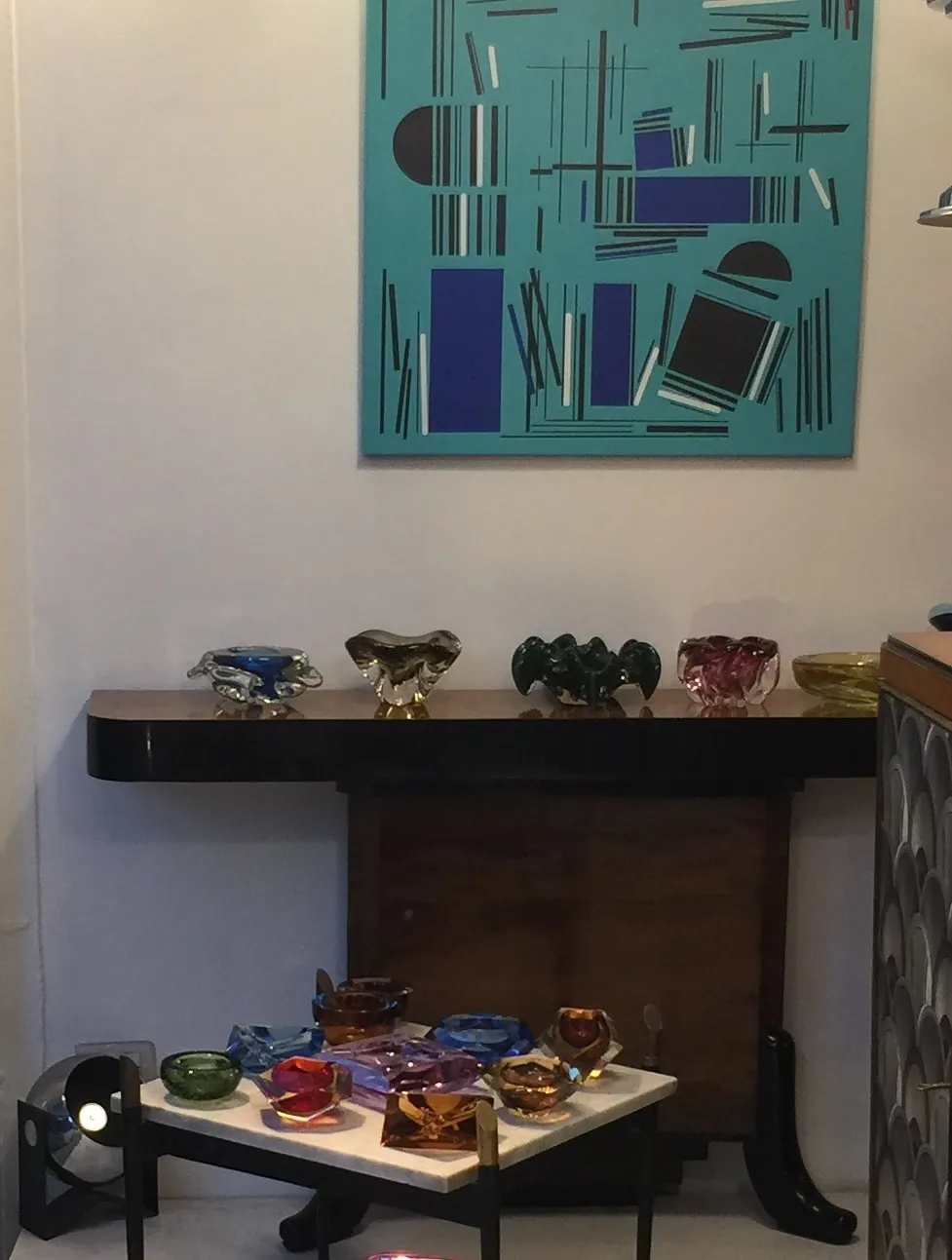 Dekorative Murano-Glasstücke in verschiedenen Farben auf einem Tisch.