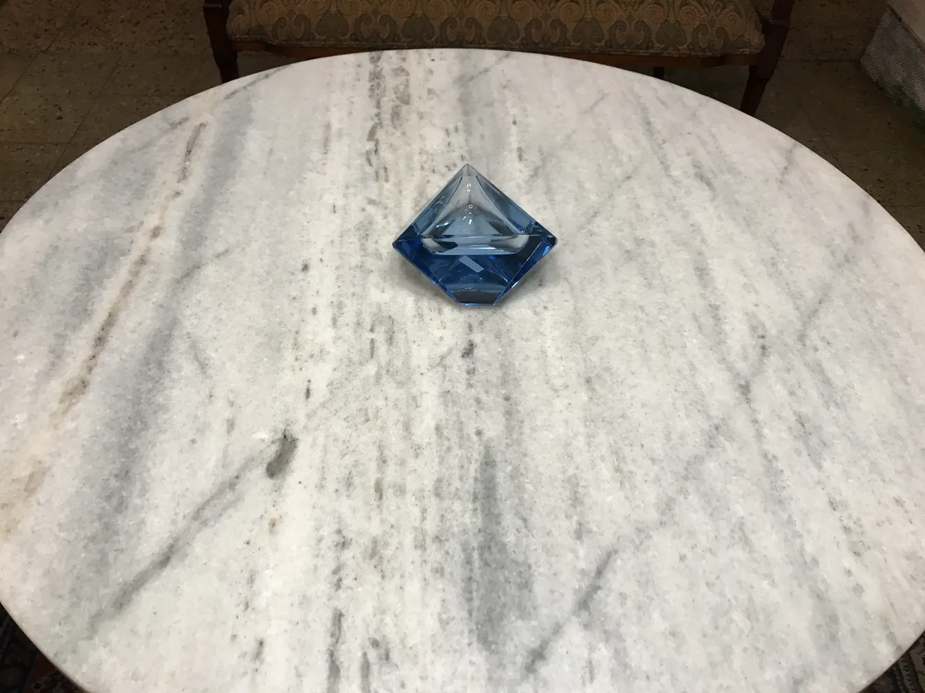 Cristal de Murano azul em forma de pirâmide sobre a mesa