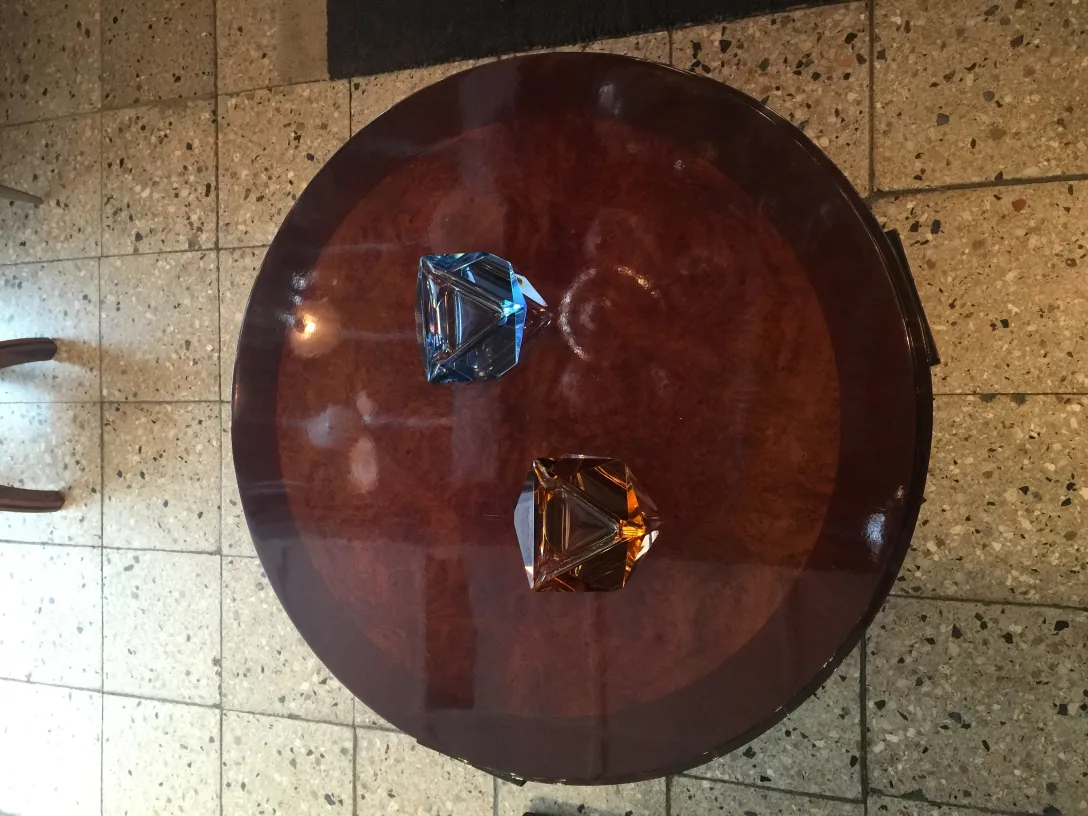 dos cristales de murano antiguo en forma de diamante, azul y ámbar sobre mesa redonda