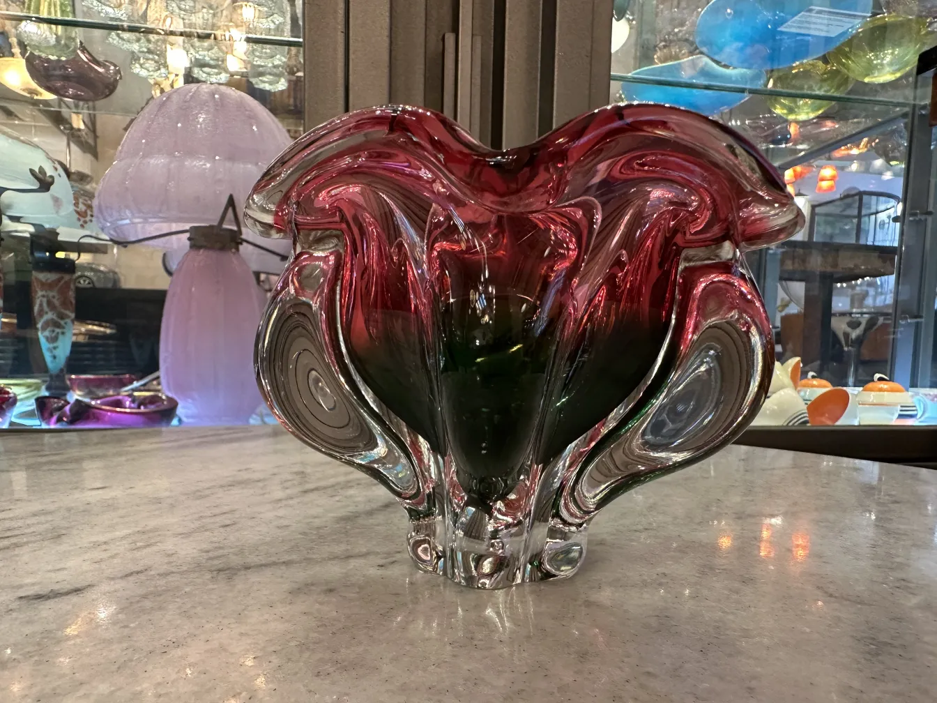 alter murano-glas vase in rot und grün mit gewundenen formen, umgeben von dekorativem ambiente