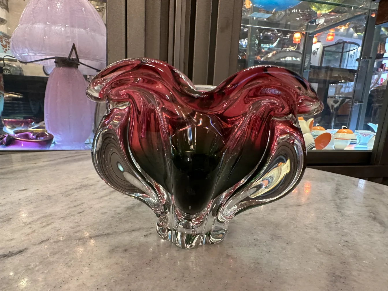 jarrón antiguo de cristal de murano en color rojo y verde con formas onduladas en un ambiente exhibición