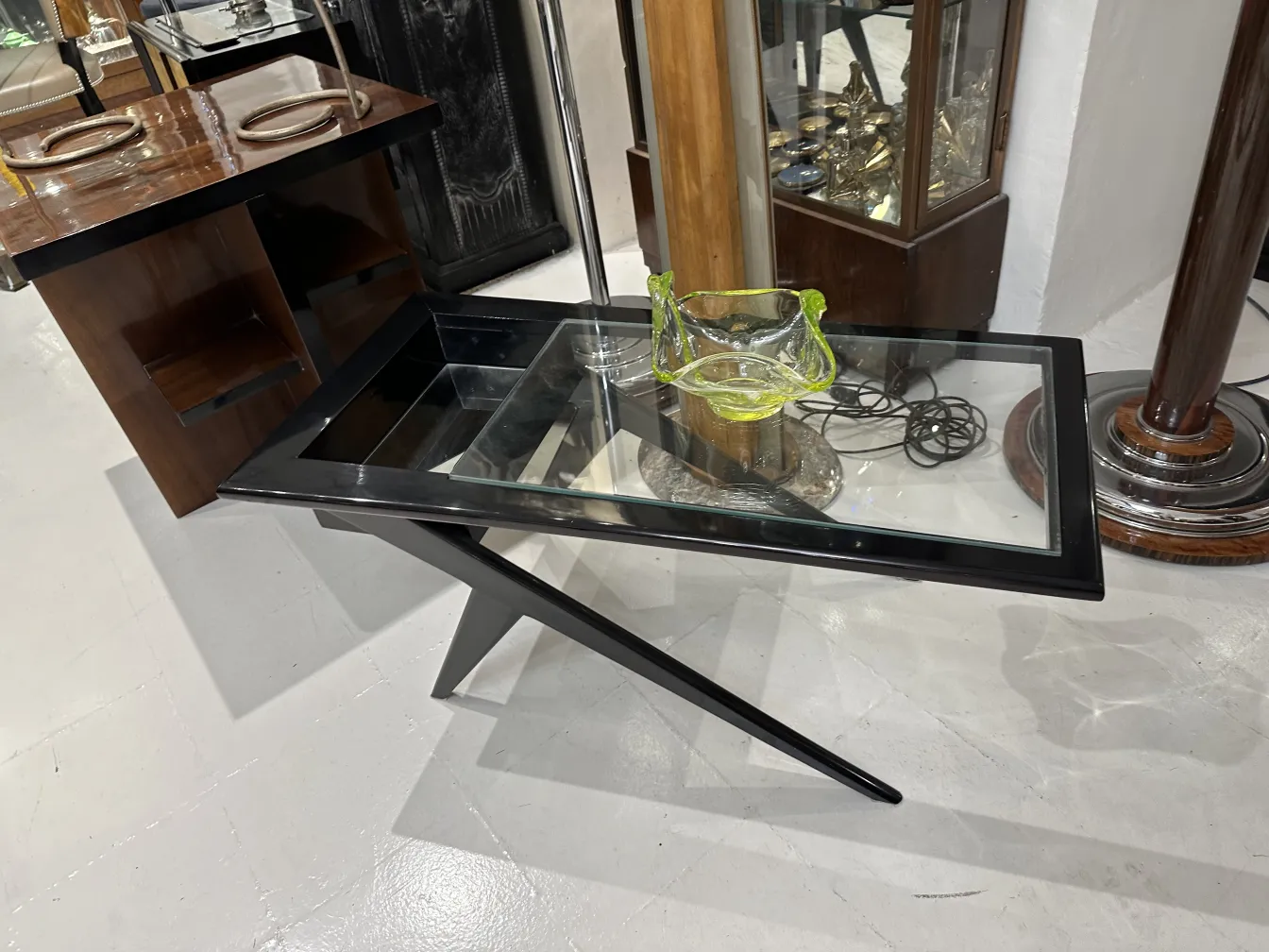 vitrine mit antikem buntes murano-glas neben vintage möbeln