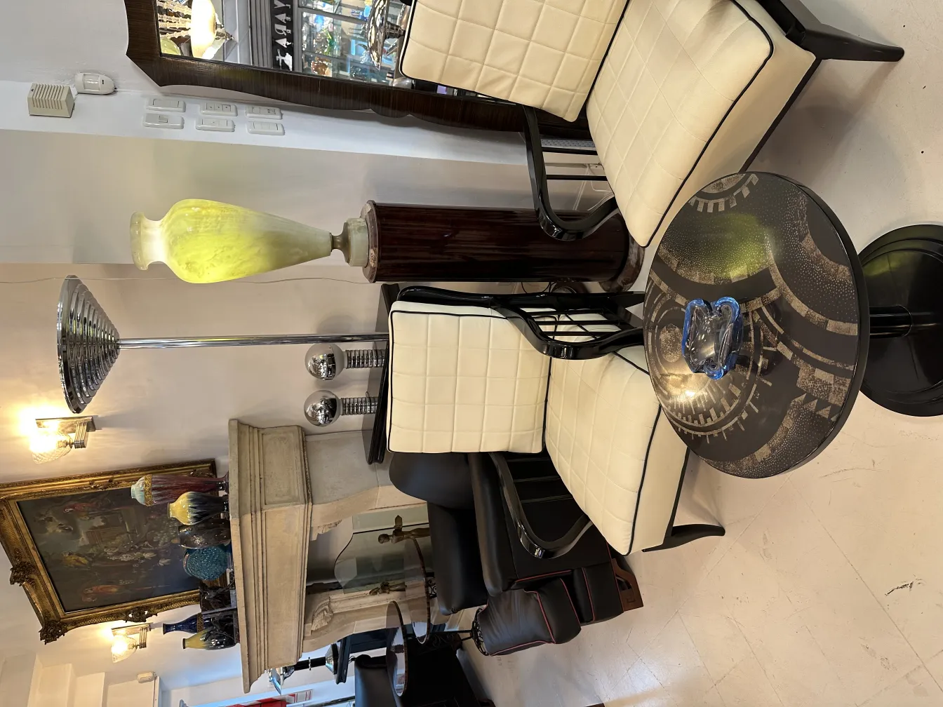 Cristal de Murano bleu sur table noire, entouré de chaises modernes