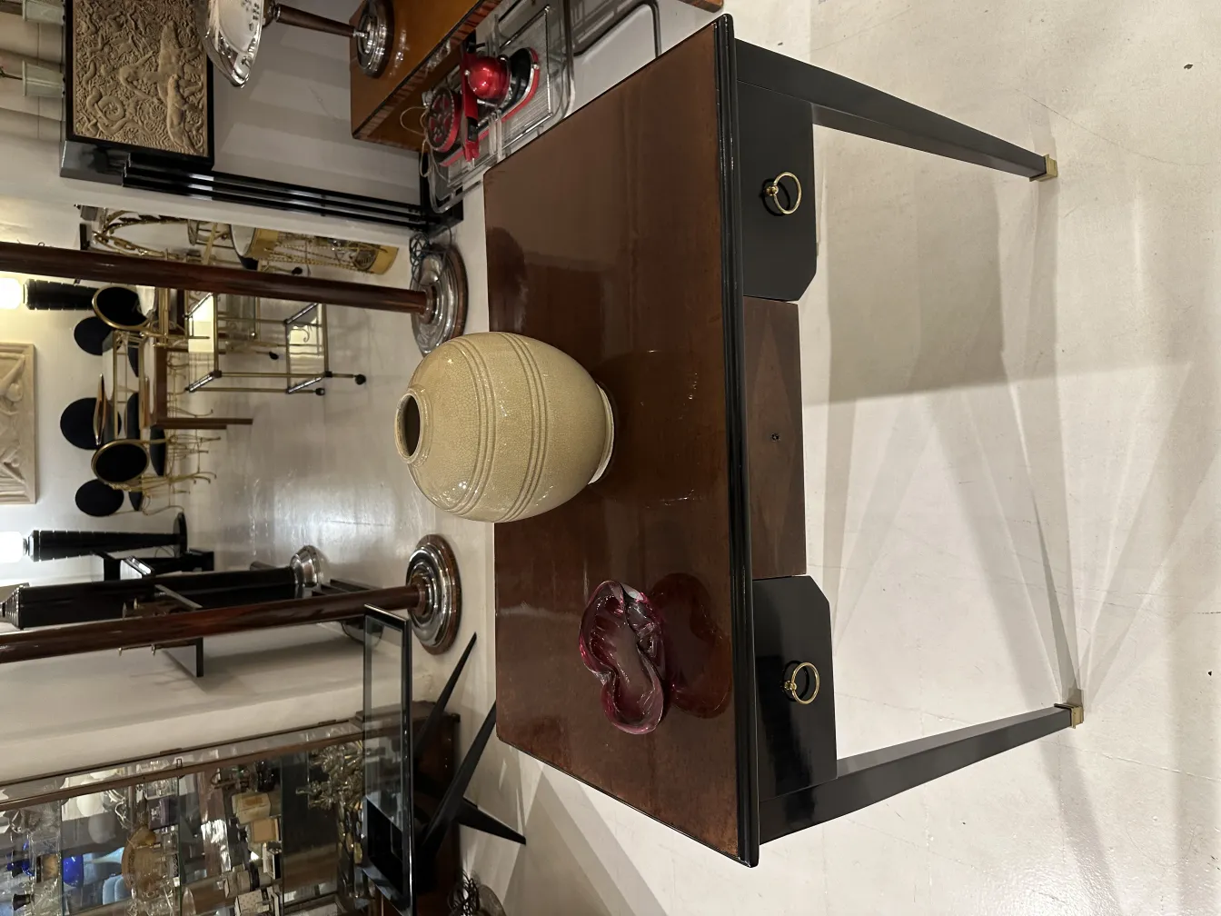 우아한 모양과 반짝이는 마감 처리가 된 무라노 유리 vase 가 앤티크로 둘러싸여 있습니다.