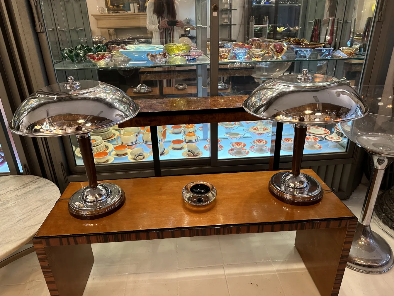 duas lâmpadas antigas com base de madeira e cristal de murano, fundo com pratos coloridos