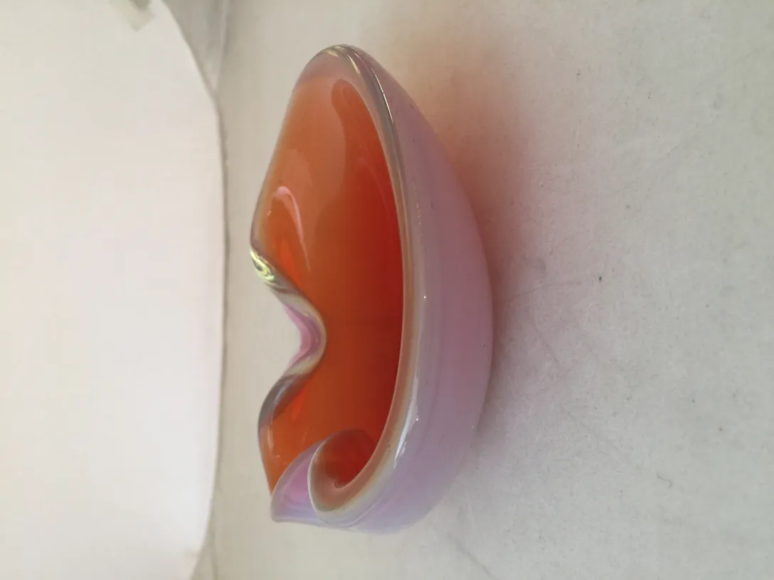 hemisphere of murano glass in orange and pink on a light background