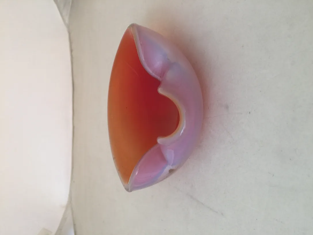 peça de vidro de murano com tons alaranjados e rosados e forma curva