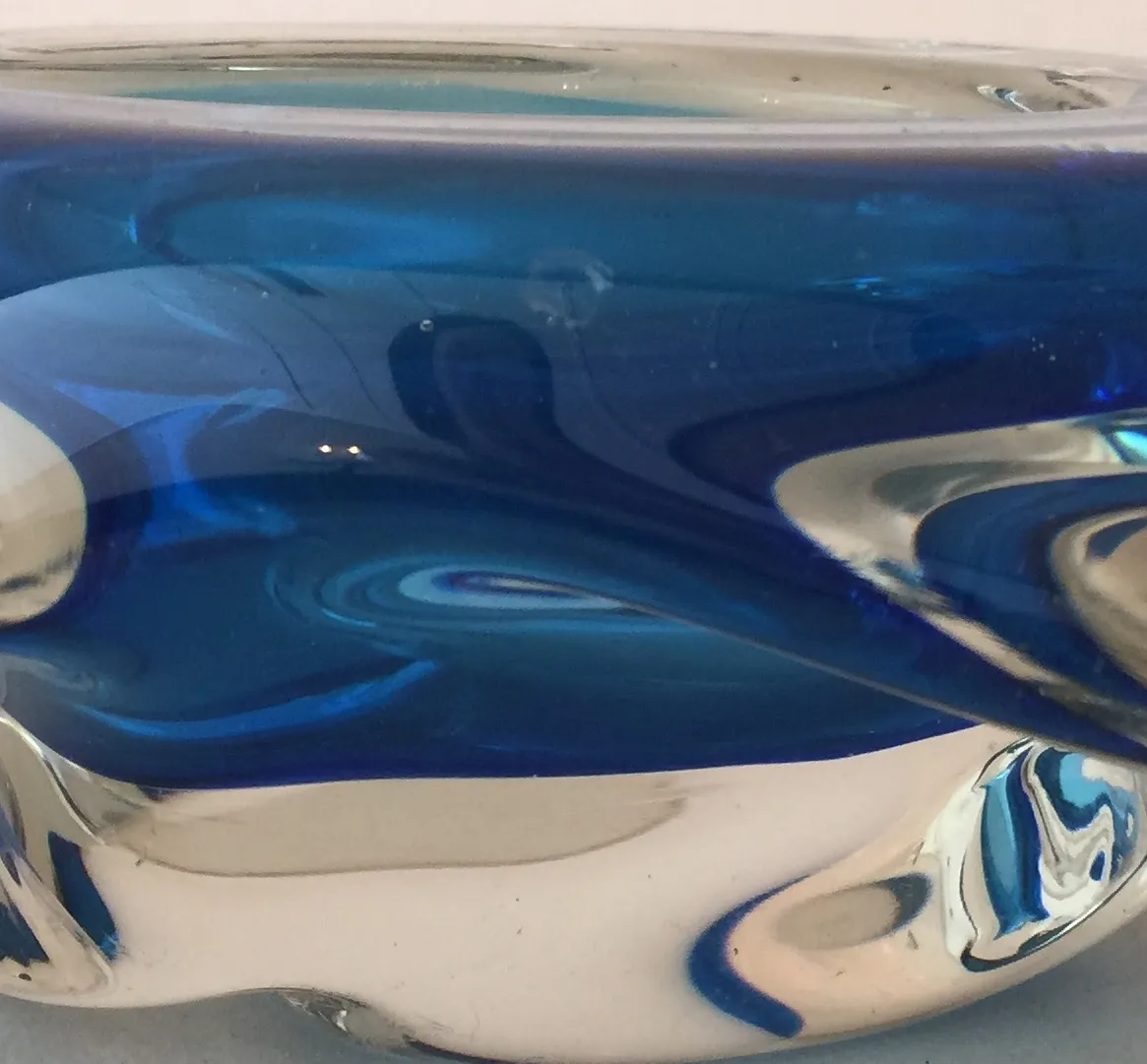 Cristal de Murano antiguo en tonos azules, con formas fluidas, fondo blanco.