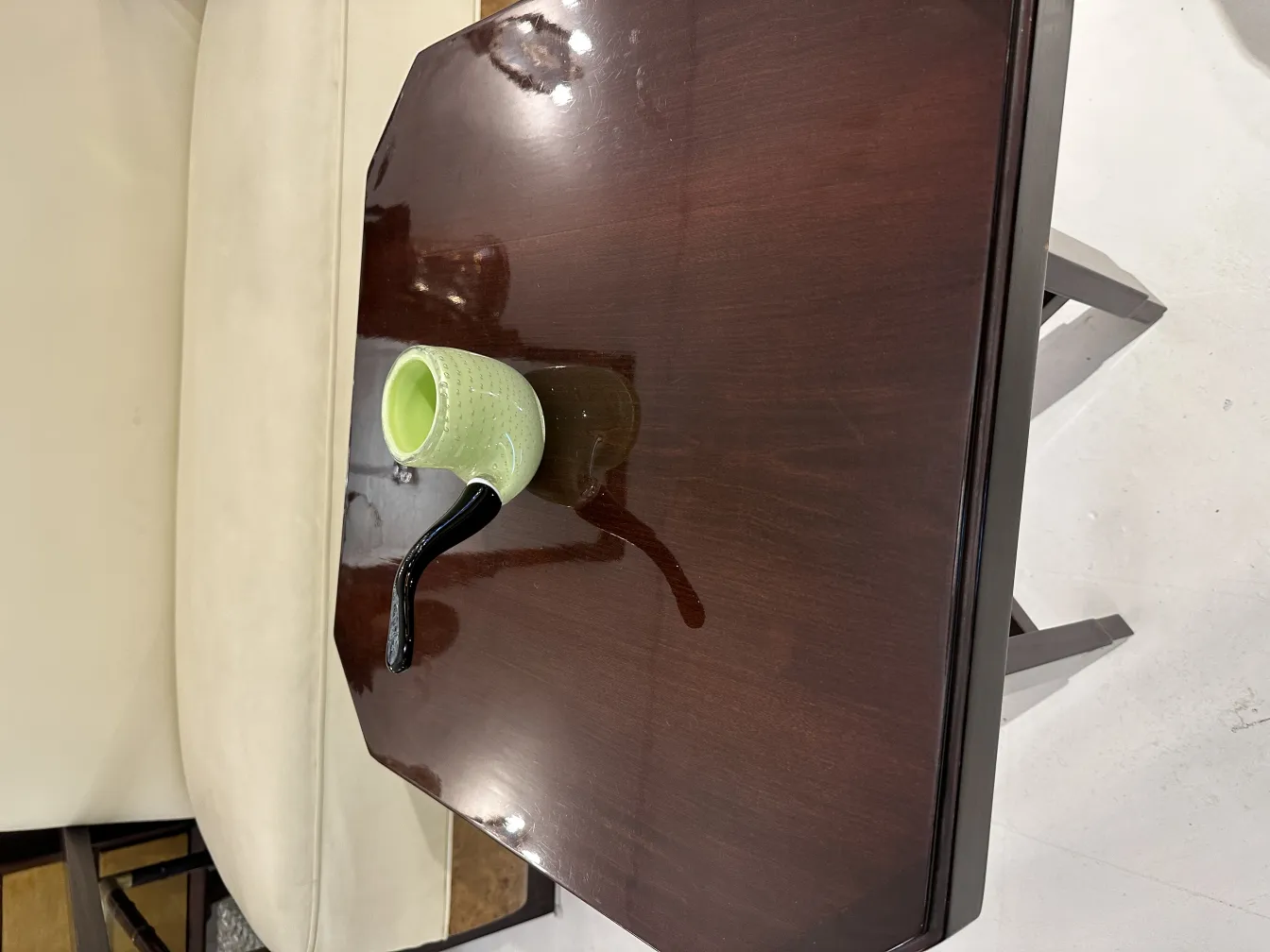 чашка из муранского стекла в элегантной обстановке, светло-зеленая с черной ручкой