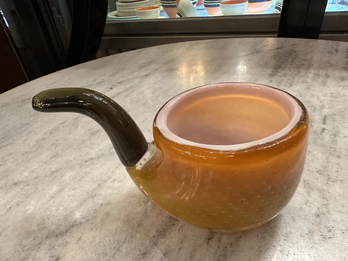 Antique Murano glass in amber color with curved spout and visual details.