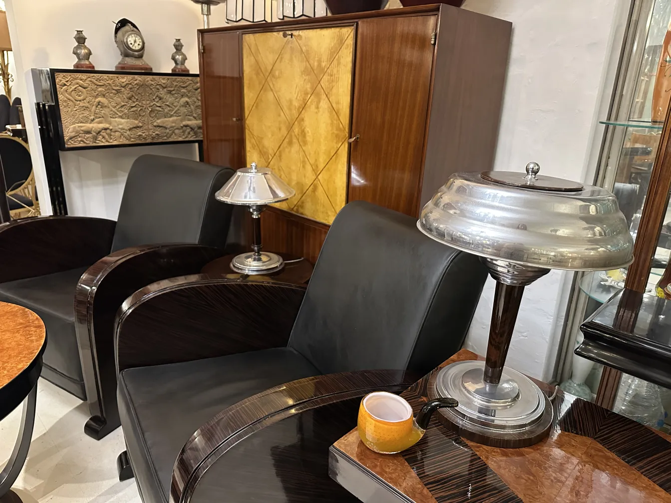 दो शानदार कुर्सियाँ, एक लैंप और एक कप एक टेबल पर