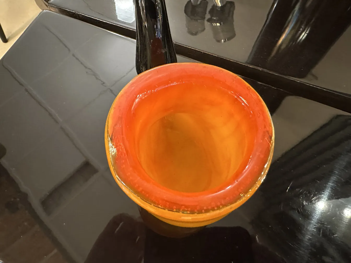 Antiguo cristal de Murano naranja con forma suave y brillante, decorado en contexto moderno.