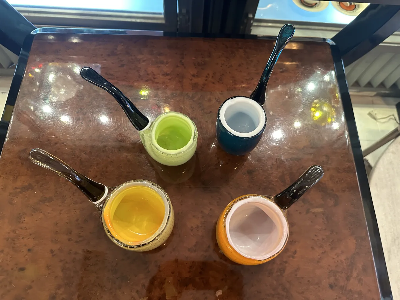 vier murano-glas-tassen in verschiedenen farben auf einem tisch