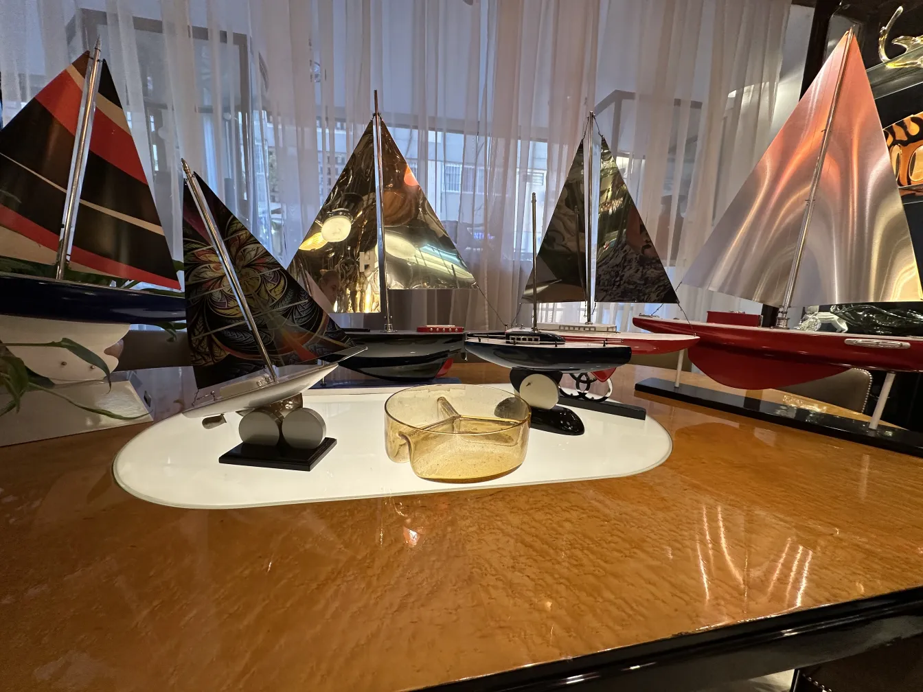 Antique Murano glass with shiny decorative details, surrounded by miniature boats.