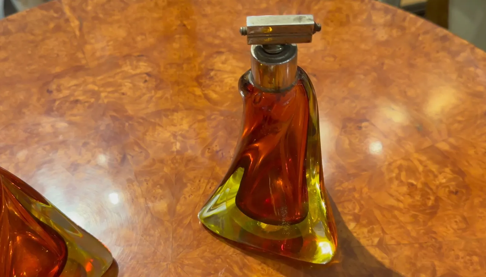 antica bottiglia in vetro di murano in tonalità ambra e verde su un tavolo di legno