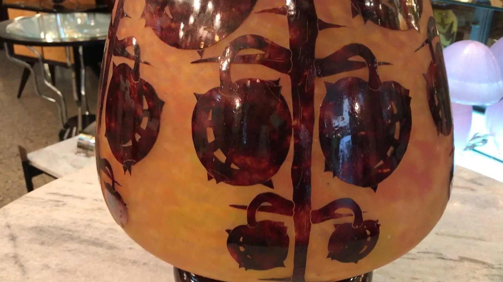 Vase en verre ancien avec des tons chauds, présentant des dessins décoratifs.