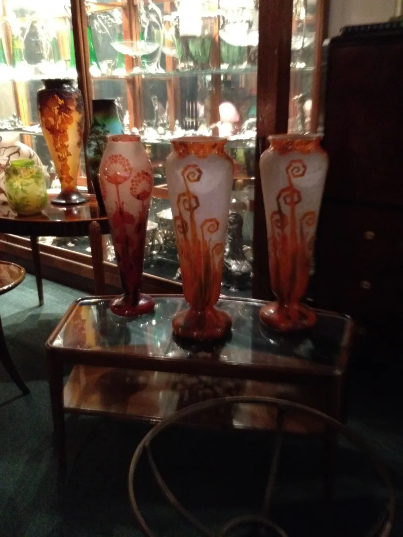 Three antique glass vases displayed in a showcase environment.