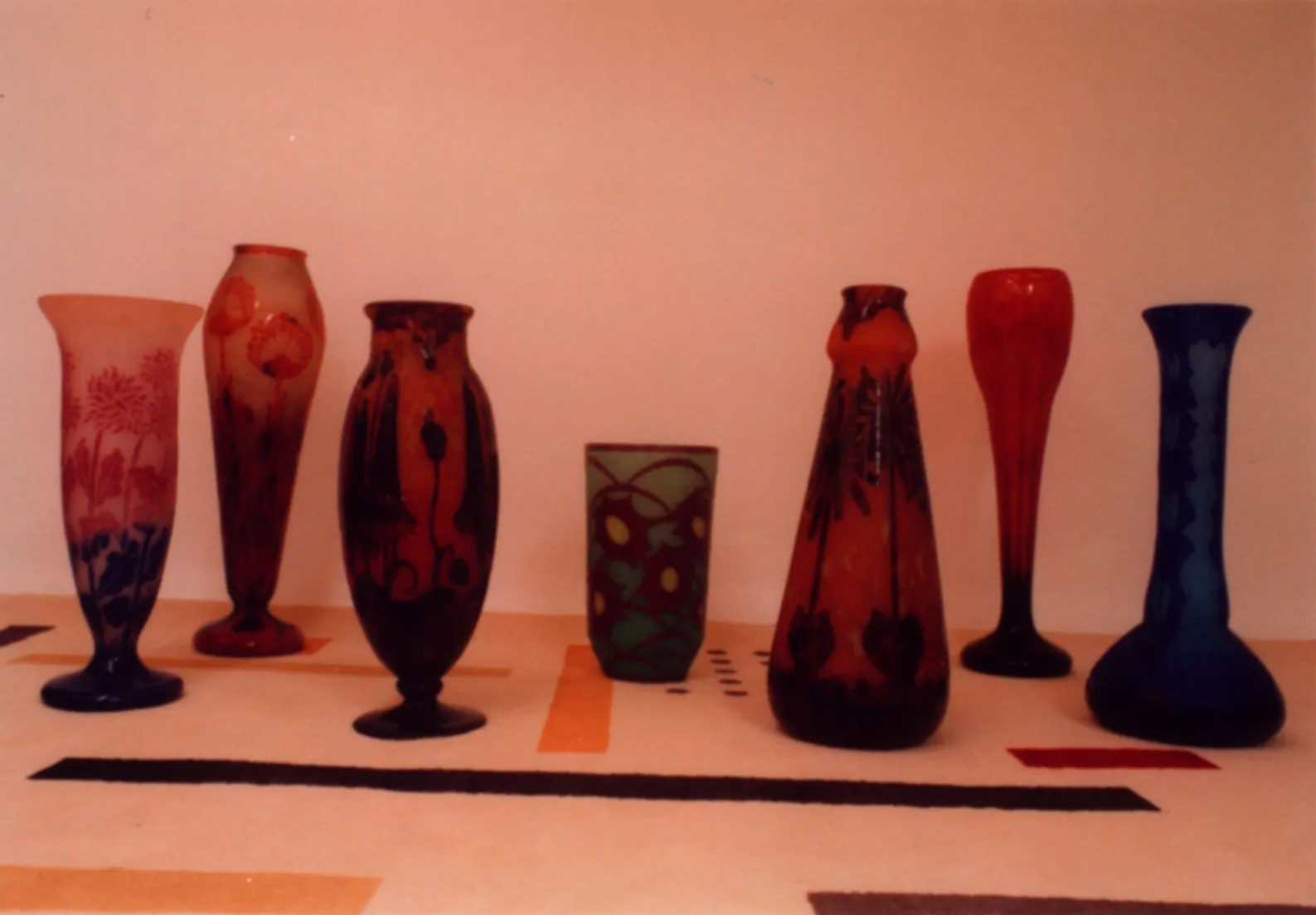 Vidrio firmado Le Verre, exposición de antigüedades con varios jarrones decorativos.