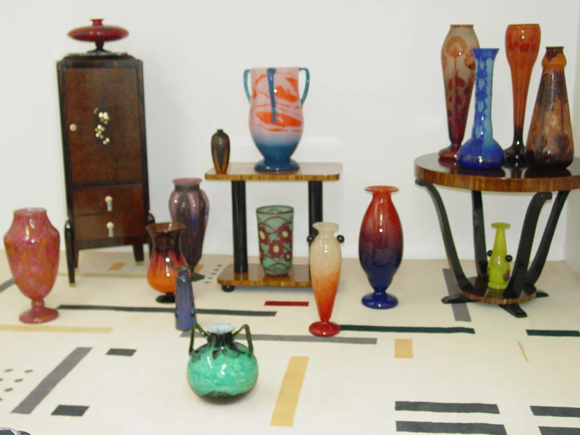 Sammlung von Antiquitäten mit verschiedenen signierten Glasvasen Le Verre in einer dekorativen Umgebung