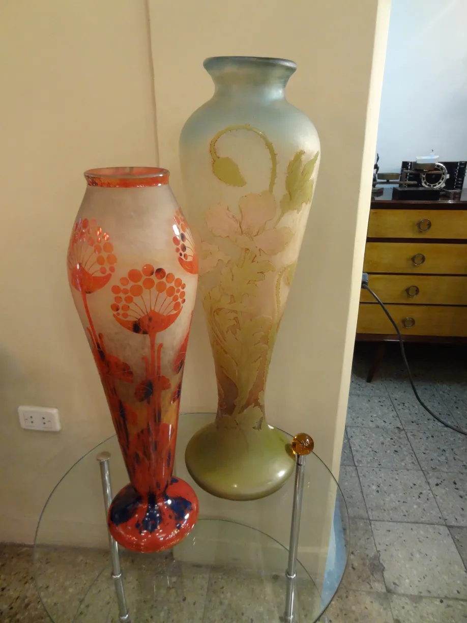 Deux vases anciens en verre avec des décorations artistiques sur une table.