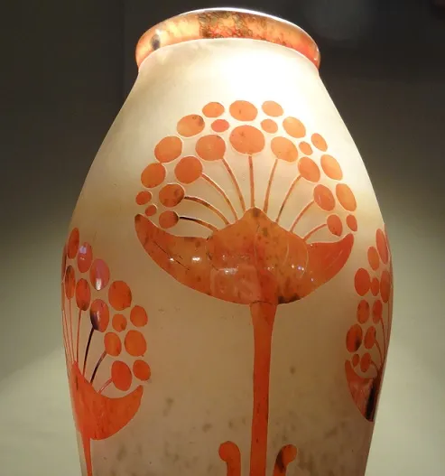 jarrón de vidrio antiguo decorado con flores en colores cálidos