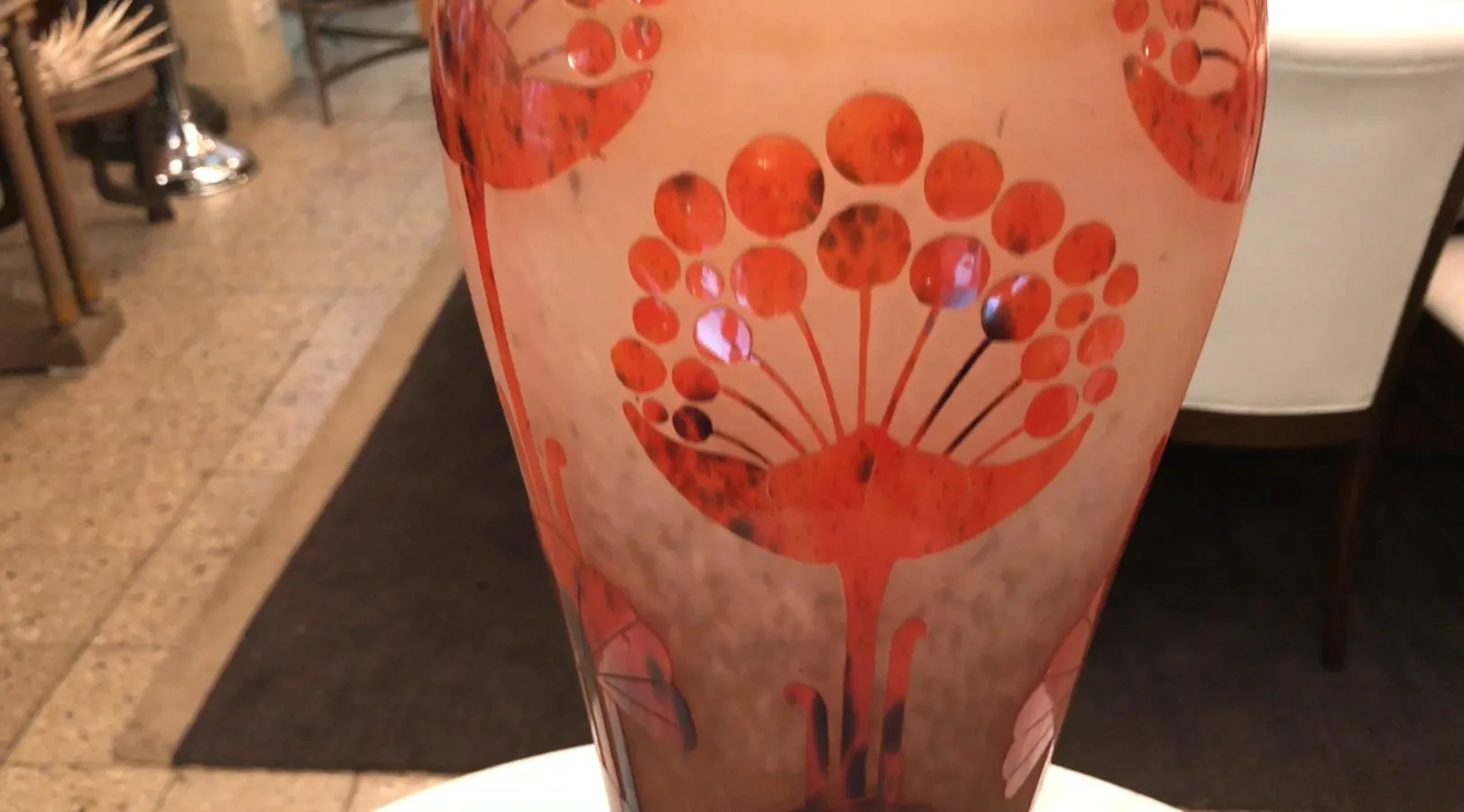 Vidrio firmado Le Verre con decoraciones rojas en el diseño.