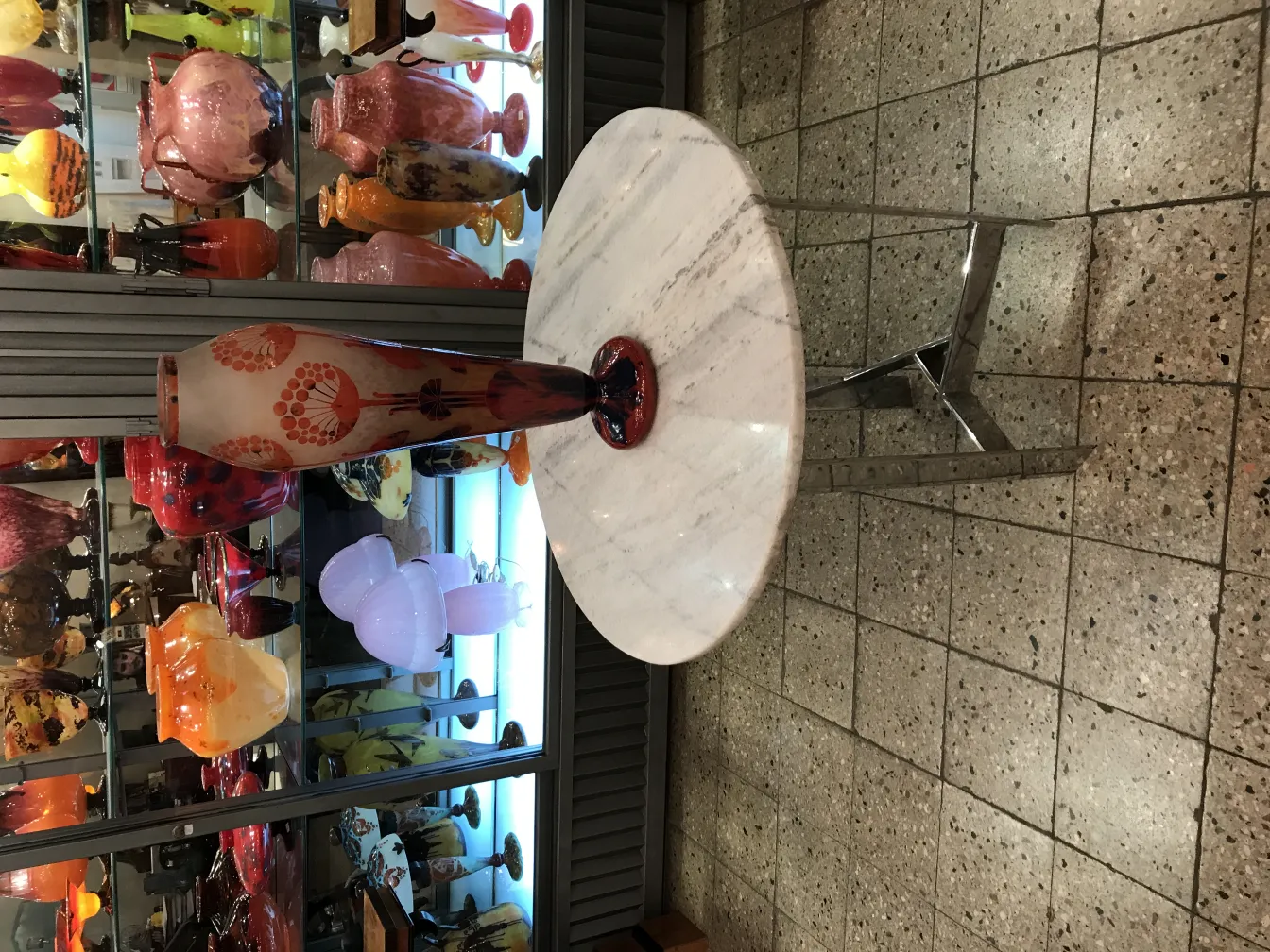 Vaso in vetro firmato Le Verre, decorato con fiori, su uno sfondo di collezioni di vetro.