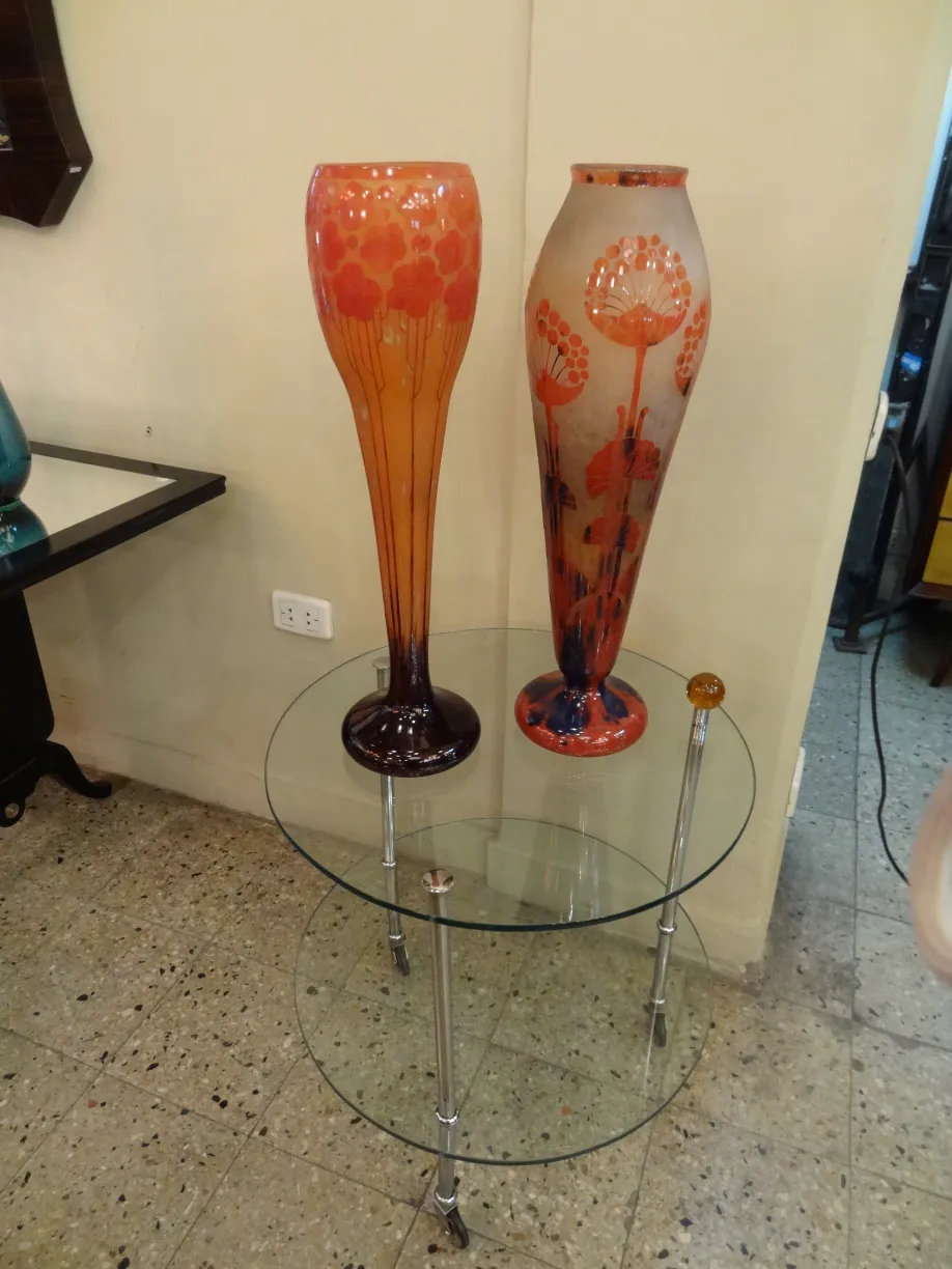 two antique glass vases with colorful designs on a table