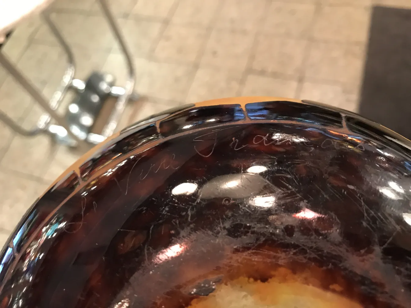 Un vetro antico con firma visibile di Le Verre nella parte superiore, sfondo sfocato.