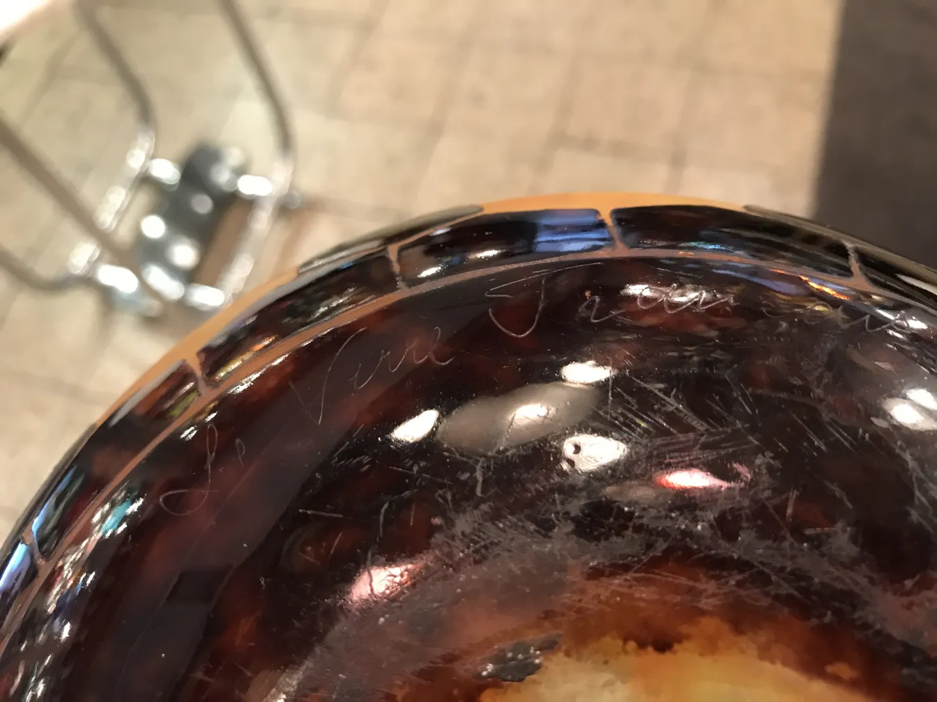 Antique signed glass Le Verre, featuring surface details. Decorative background.