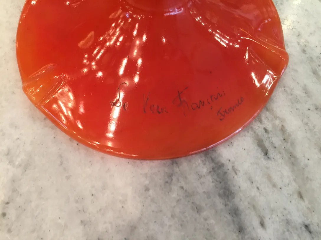 vidrio firmado de color naranja intenso con firma visible.