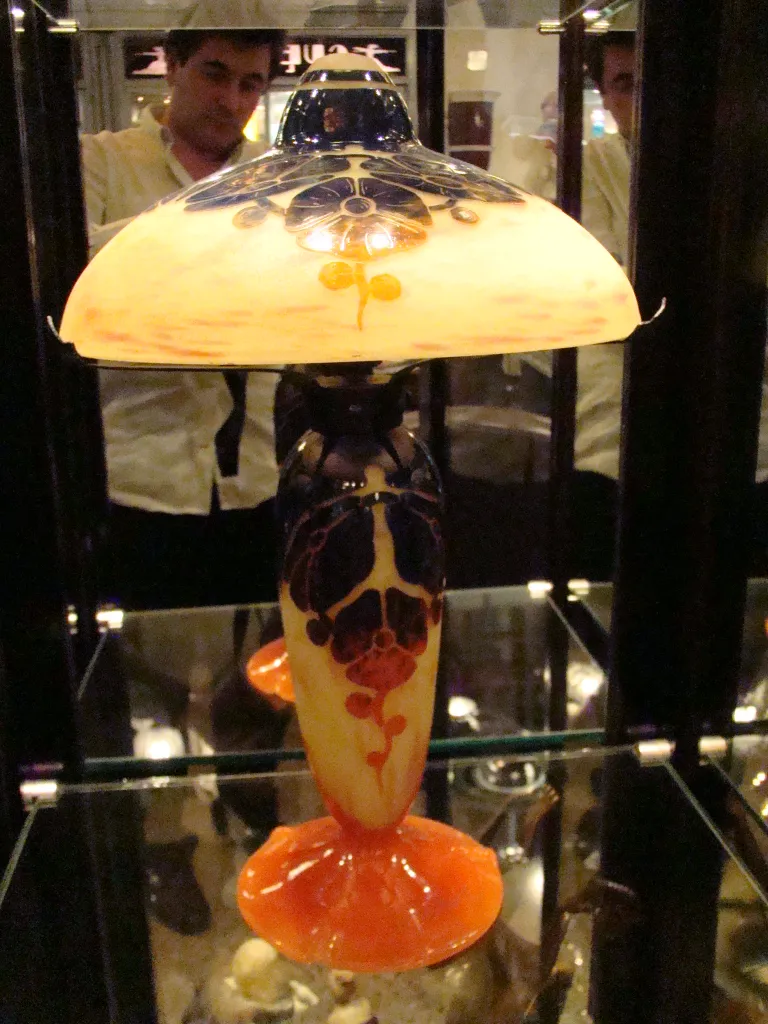 Antike signierte Glaslampe Le Verre mit lebendigen Farben in einer beleuchteten Vitrine.