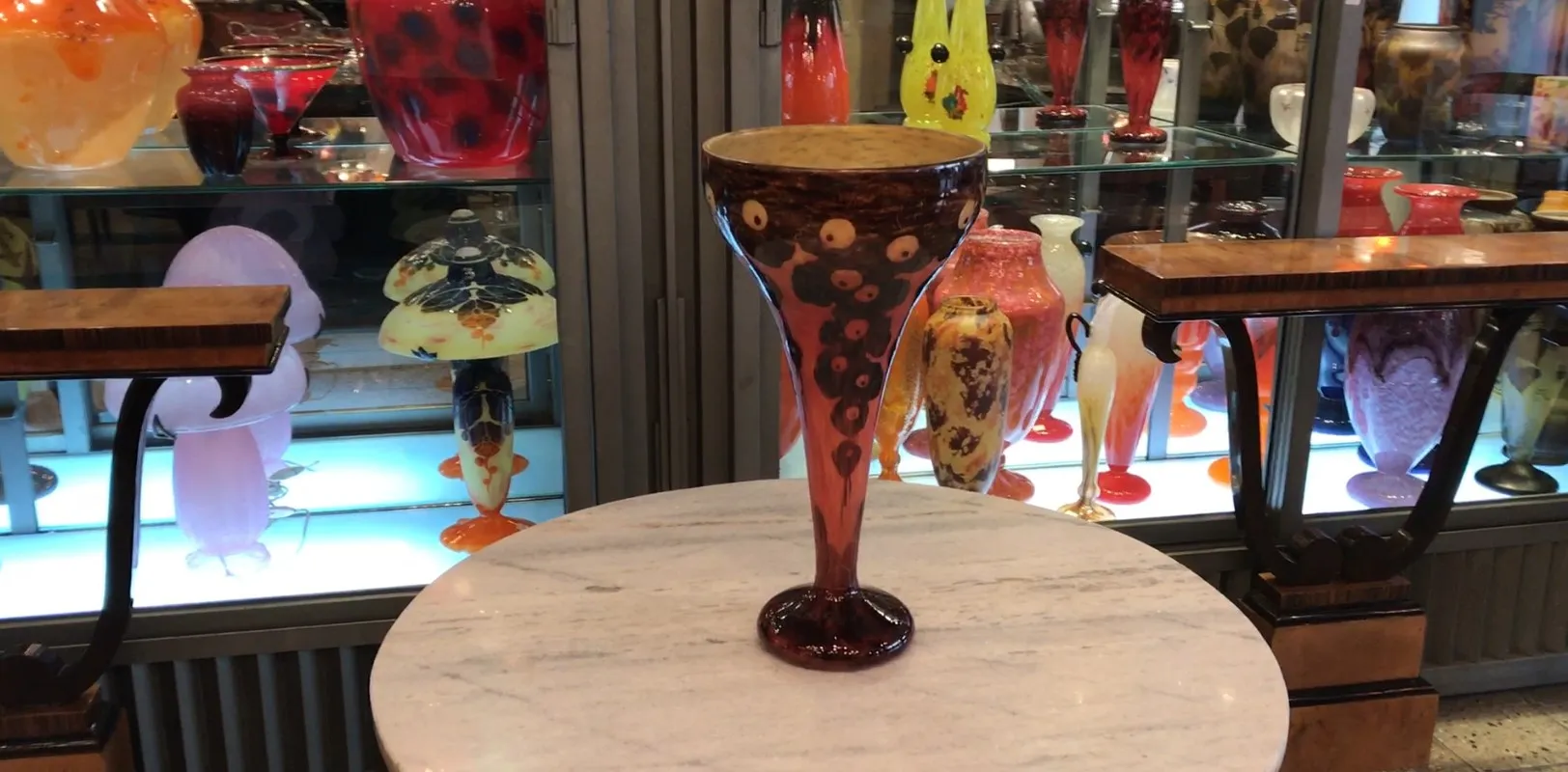 Vetro firmato Le Verre con design colorato su scaffali.