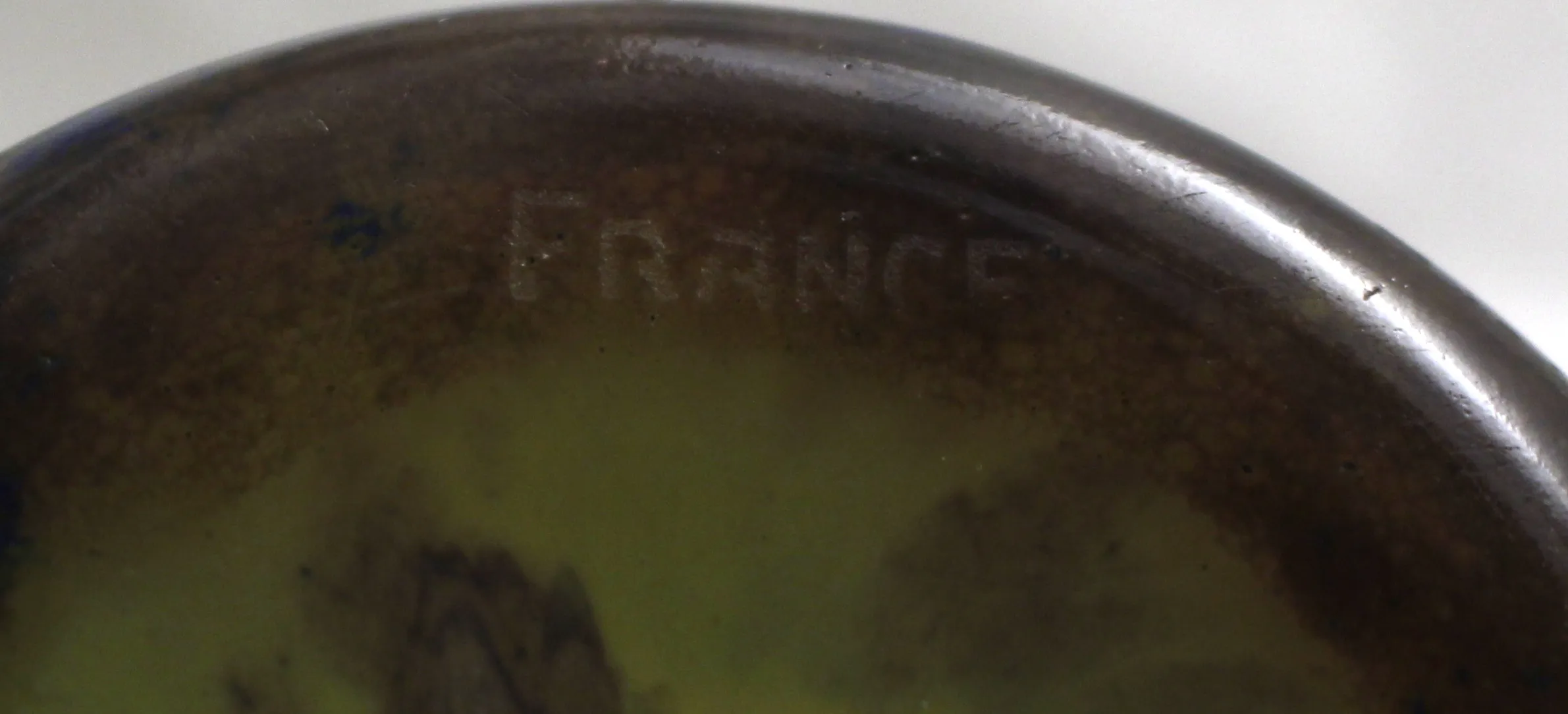 Vetro firmato Le Verre con dettagli antichi, sfondo decorato.