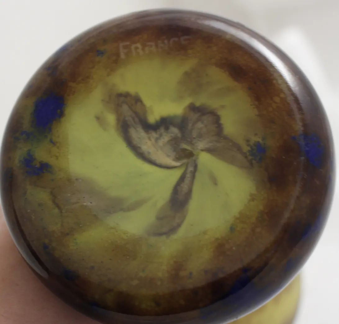 Vue de la base d'un verre signé Le Verre, avec des teintes vertes et bleues.