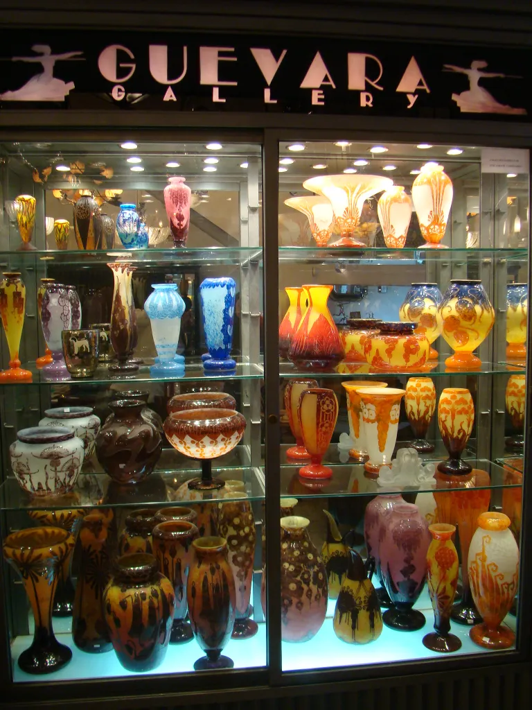 Vitrine avec antiquités en verre signé Le Verre de différentes formes et couleurs.