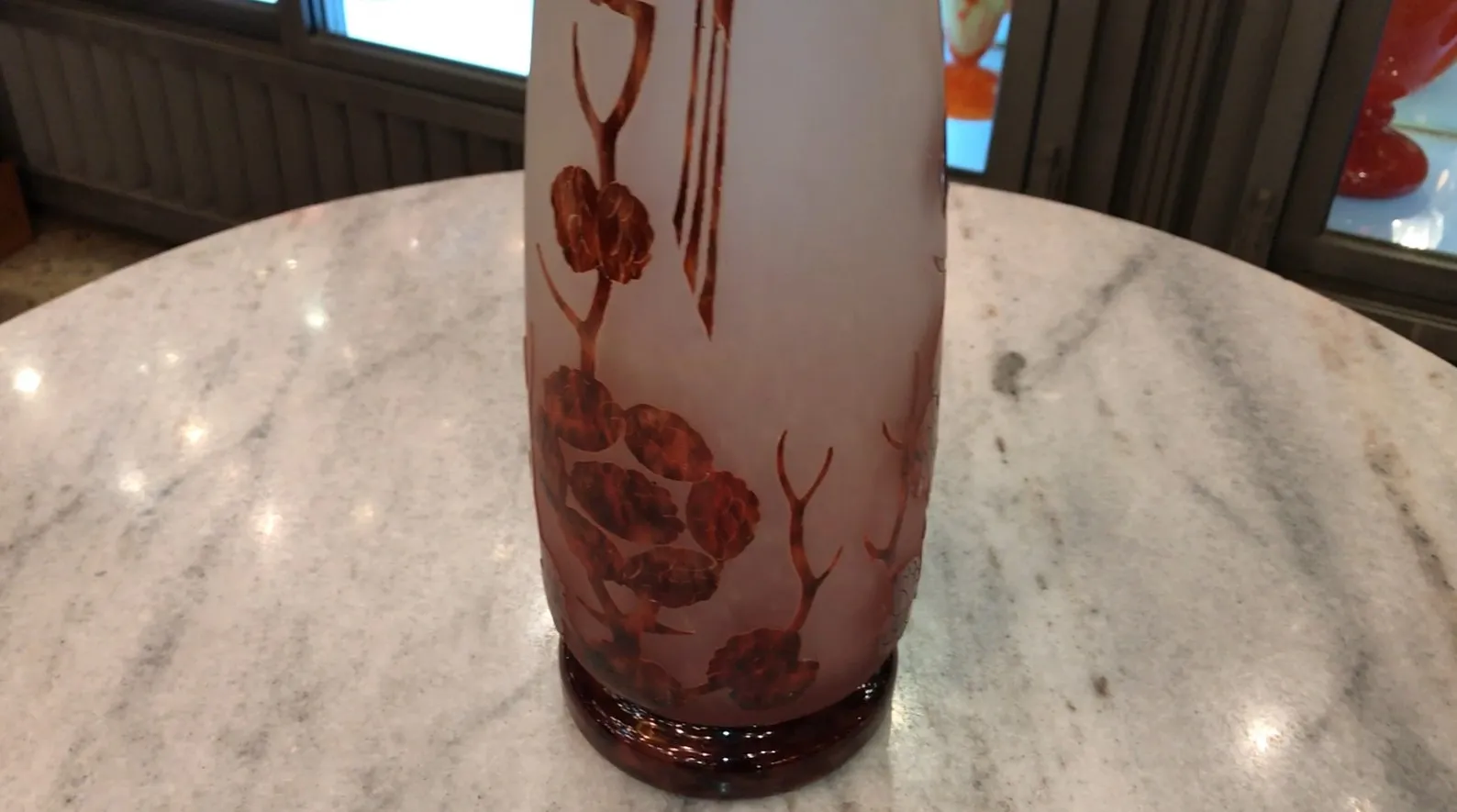 Vidrio firmado Le Verre con diseño decorativo y detalles artísticos en un entorno antiguo.