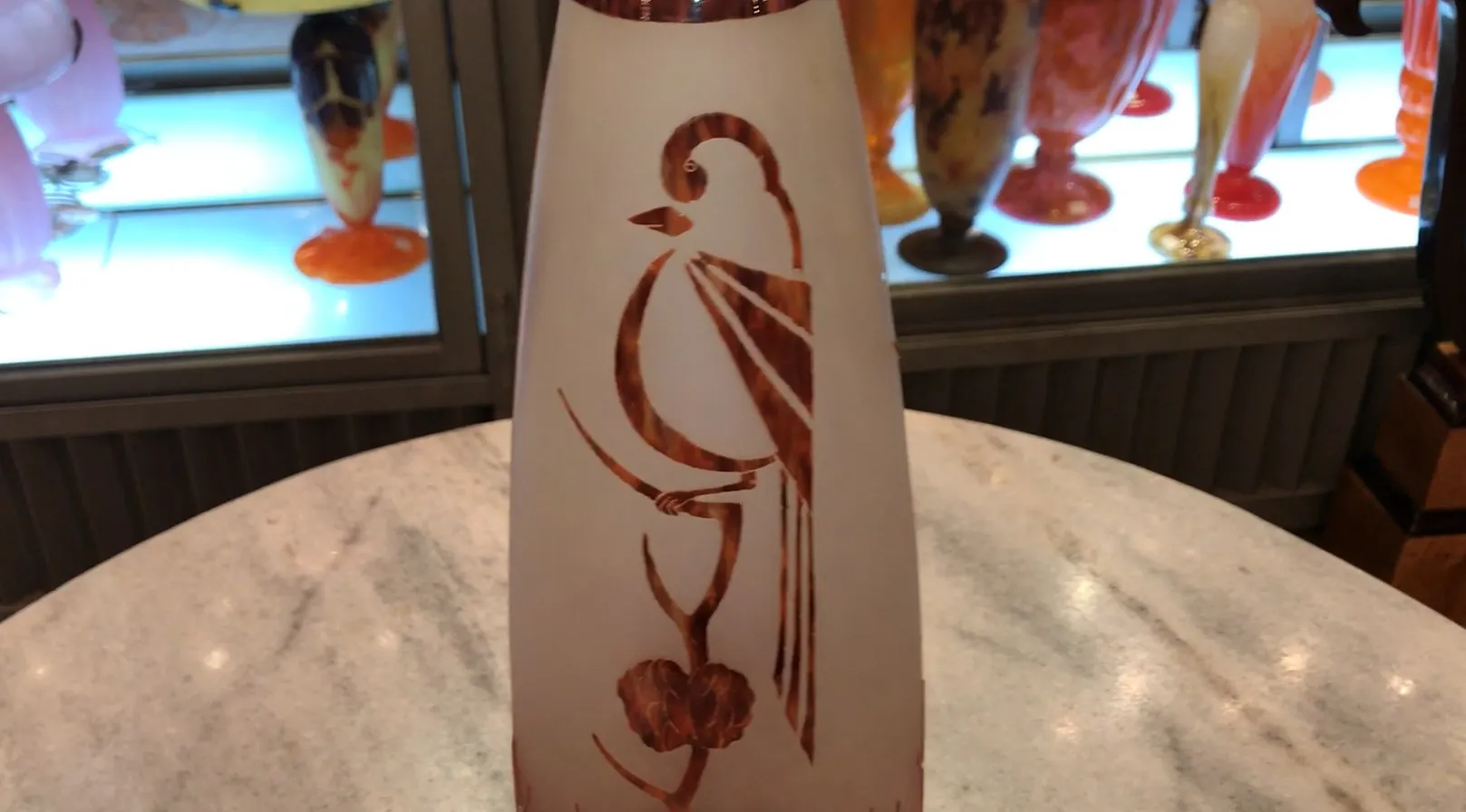 Signed glass with a bird and flower design in light tones