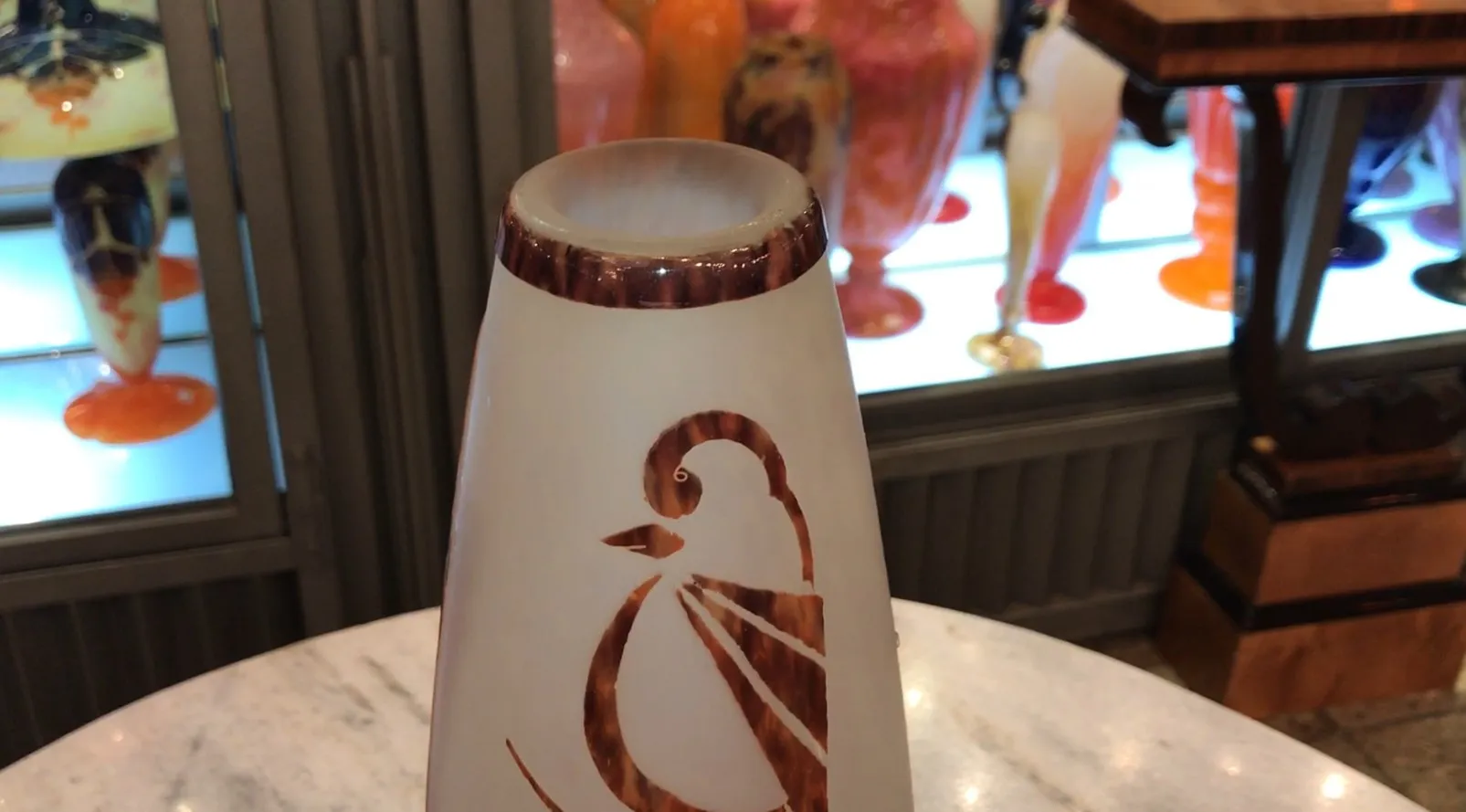 SIGNED GLASS Le Verre with decorative design against a colorful background