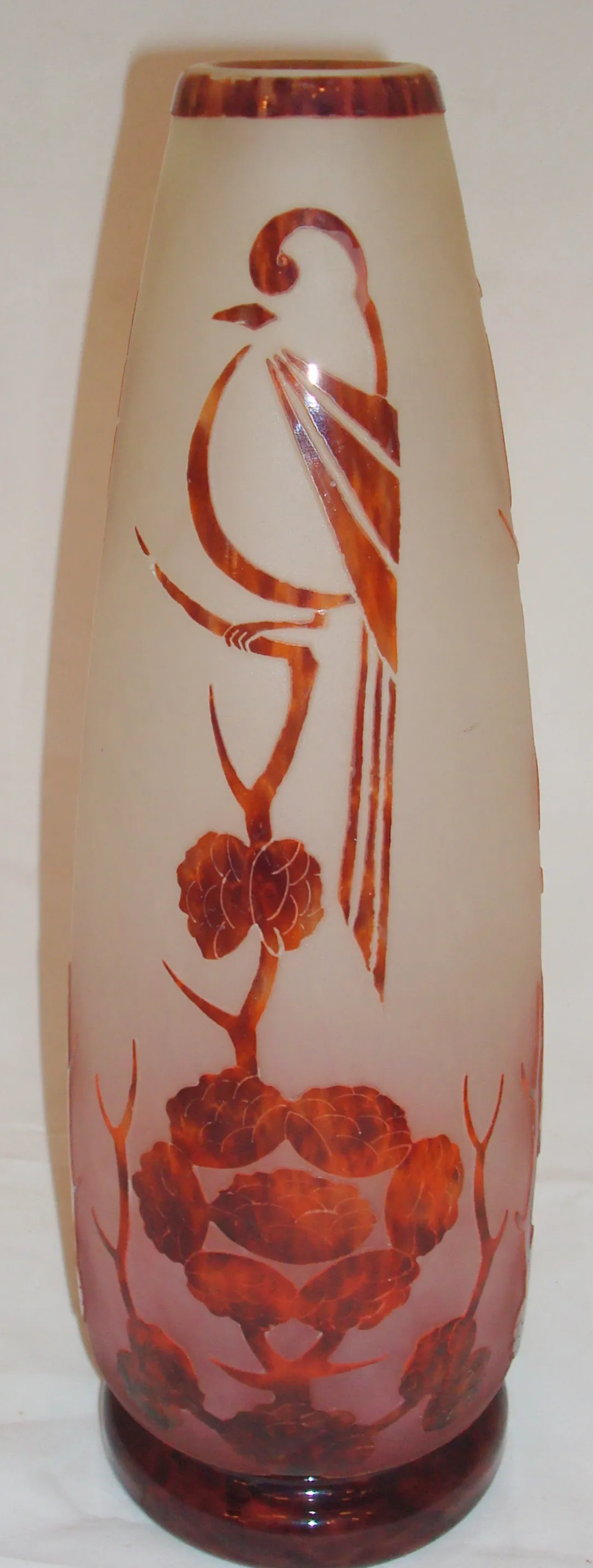 Glasvase mit graviertem Design von Vögeln und Blumen in bernsteinfarbenen Tönen, cremefarbenem Hintergrund.