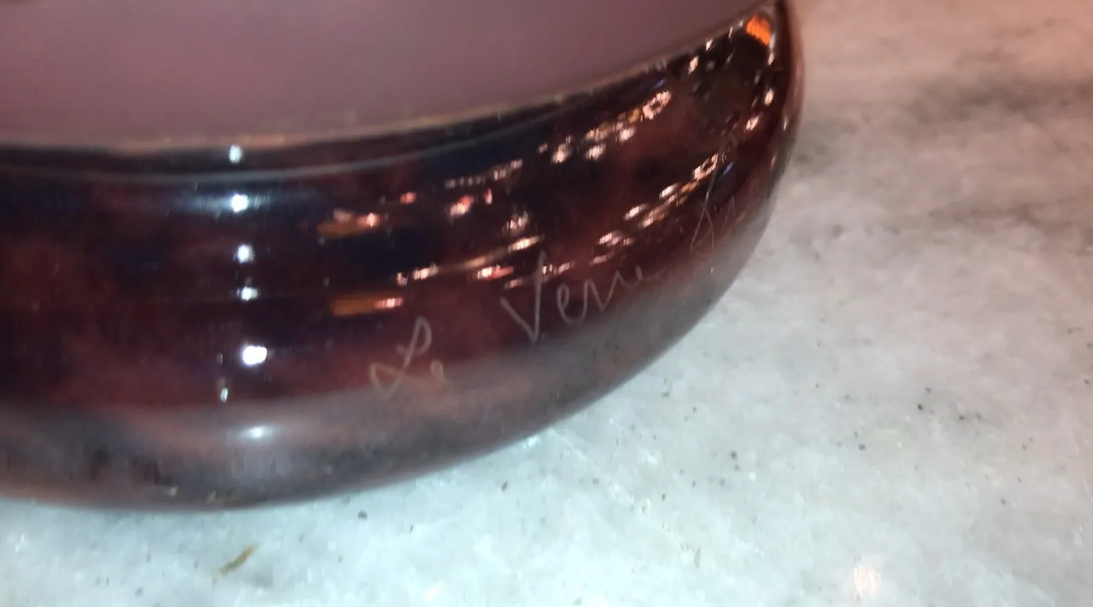 signiertes Glas in dunklen Tönen mit sichtbarer Unterschrift