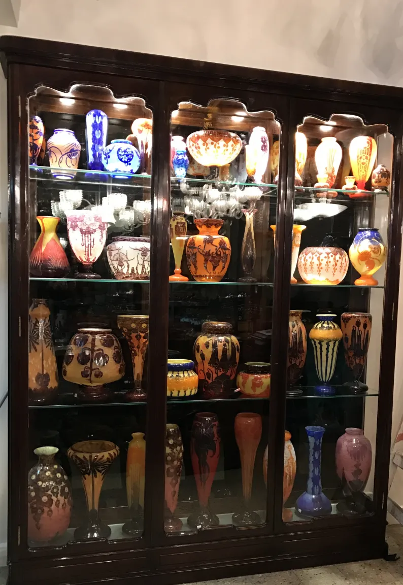 ausstellung von signiertem glas in einer antikvitrine