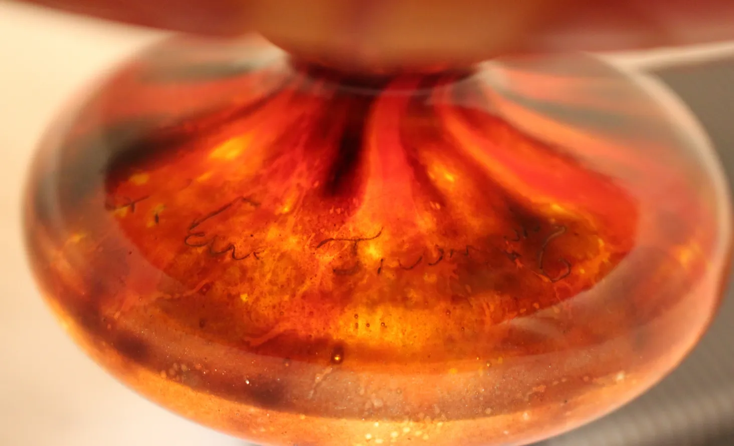 Verre signé Le Verre avec des couleurs chaudes et des reflets, vue rapprochée