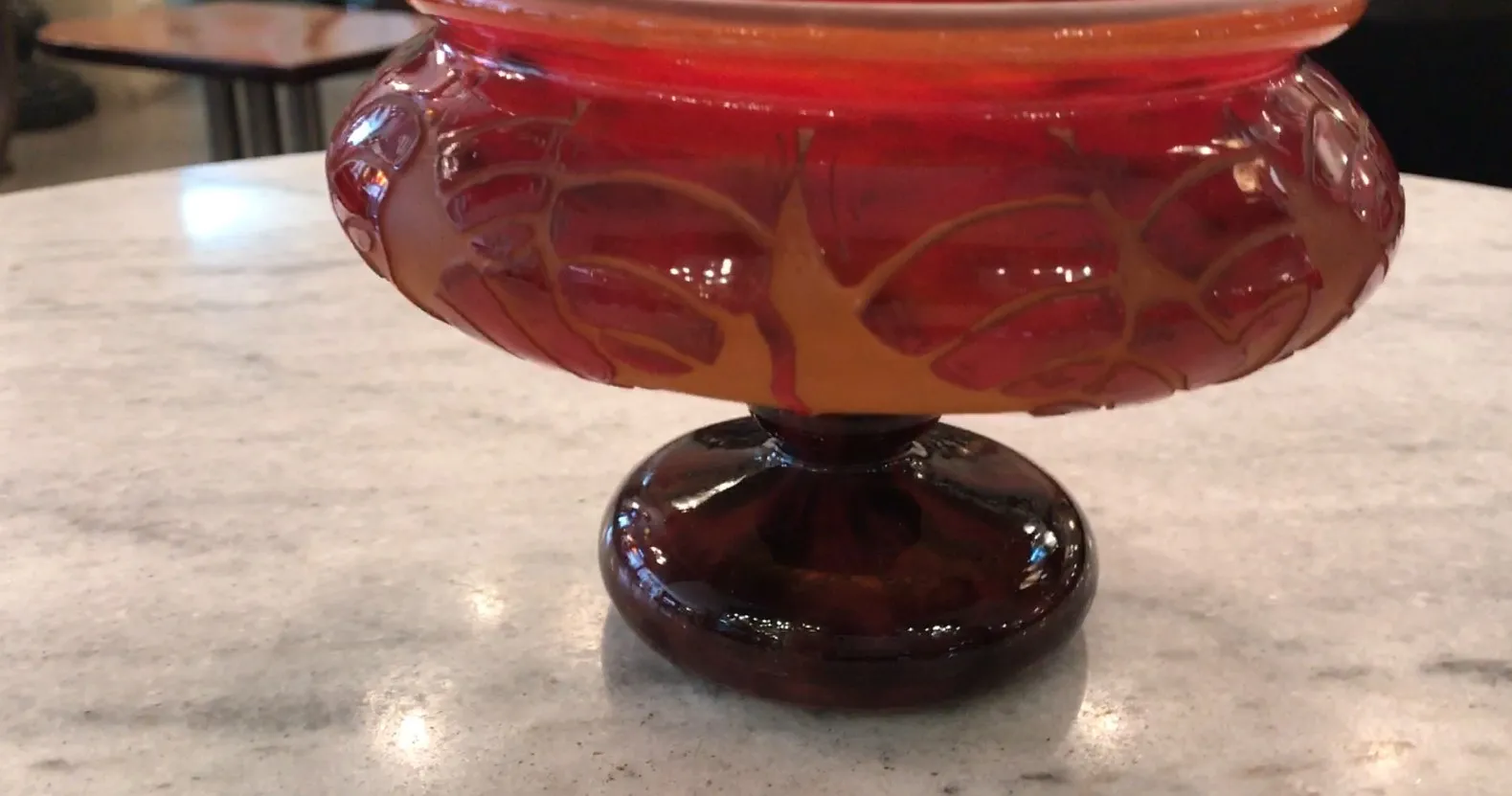 Antique glass bowl signed Le Verre, featuring elegant design and warm colors, set on a clear surface.